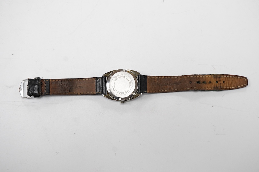 A gentleman's stainless steel manual wind wrist watch, retailed by Garrard, with baton numerals, case diameter 33mm, on a black leather strap.